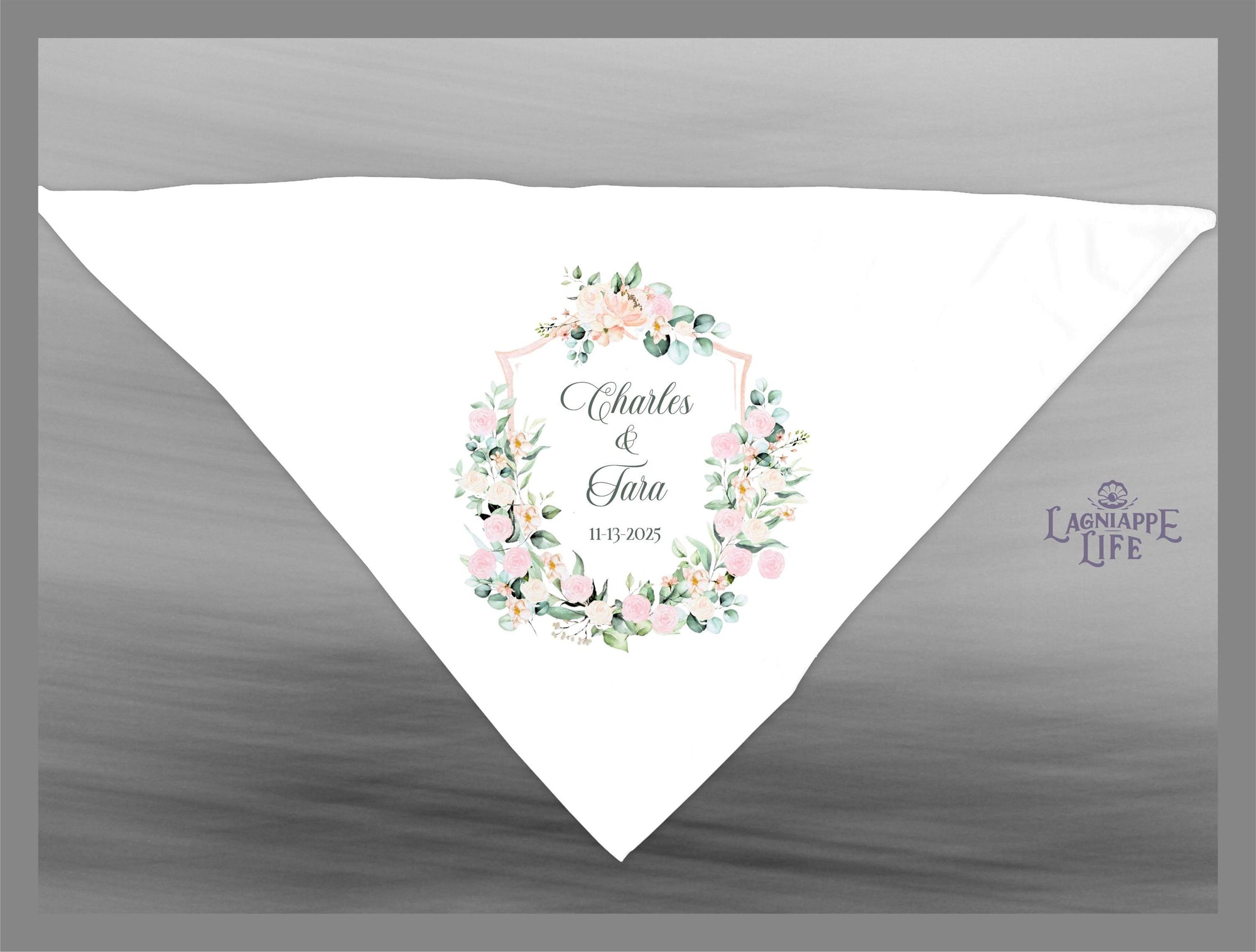 May include: A white wedding favor bag with a floral design and the text &#39;Charles & Tara 11.13.2025&#39; in the center. The bag has a light pink and green floral wreath with a white shield in the center. The text &#39;Lagniappe Life&#39; is in the bottom right corner of the bag.