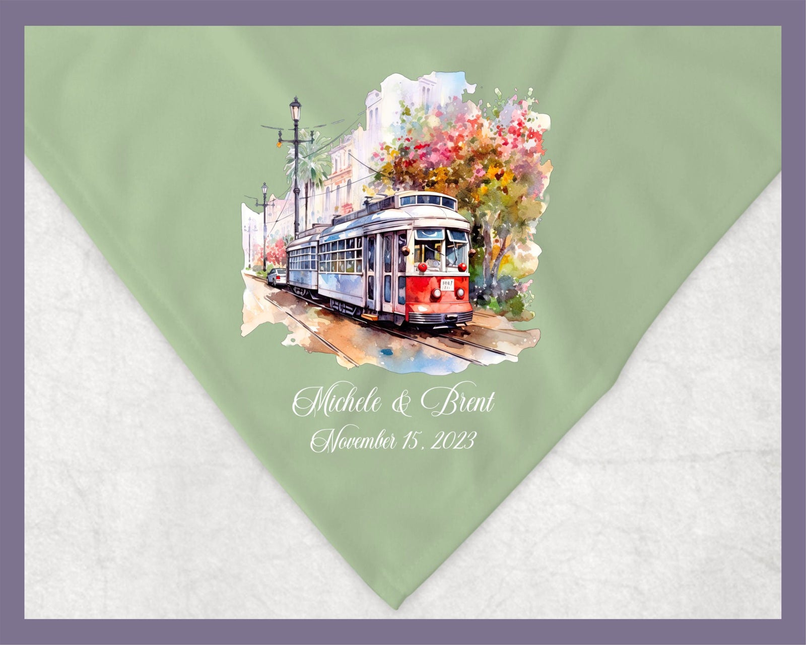 May include: A green and white fleece blanket with a watercolor illustration of a red and blue streetcar in a city setting. The text &#39;Michele & Brent November 15, 2023&#39; is printed in white below the illustration.