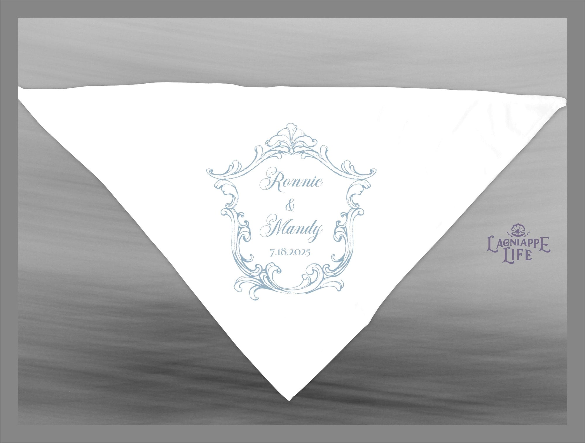 May include: A white wedding favor with a blue and white ornate design. The design includes the names Ronnie and Mandy and the date 7-18-2025. The text Lagniappe Life is in the bottom right corner.
