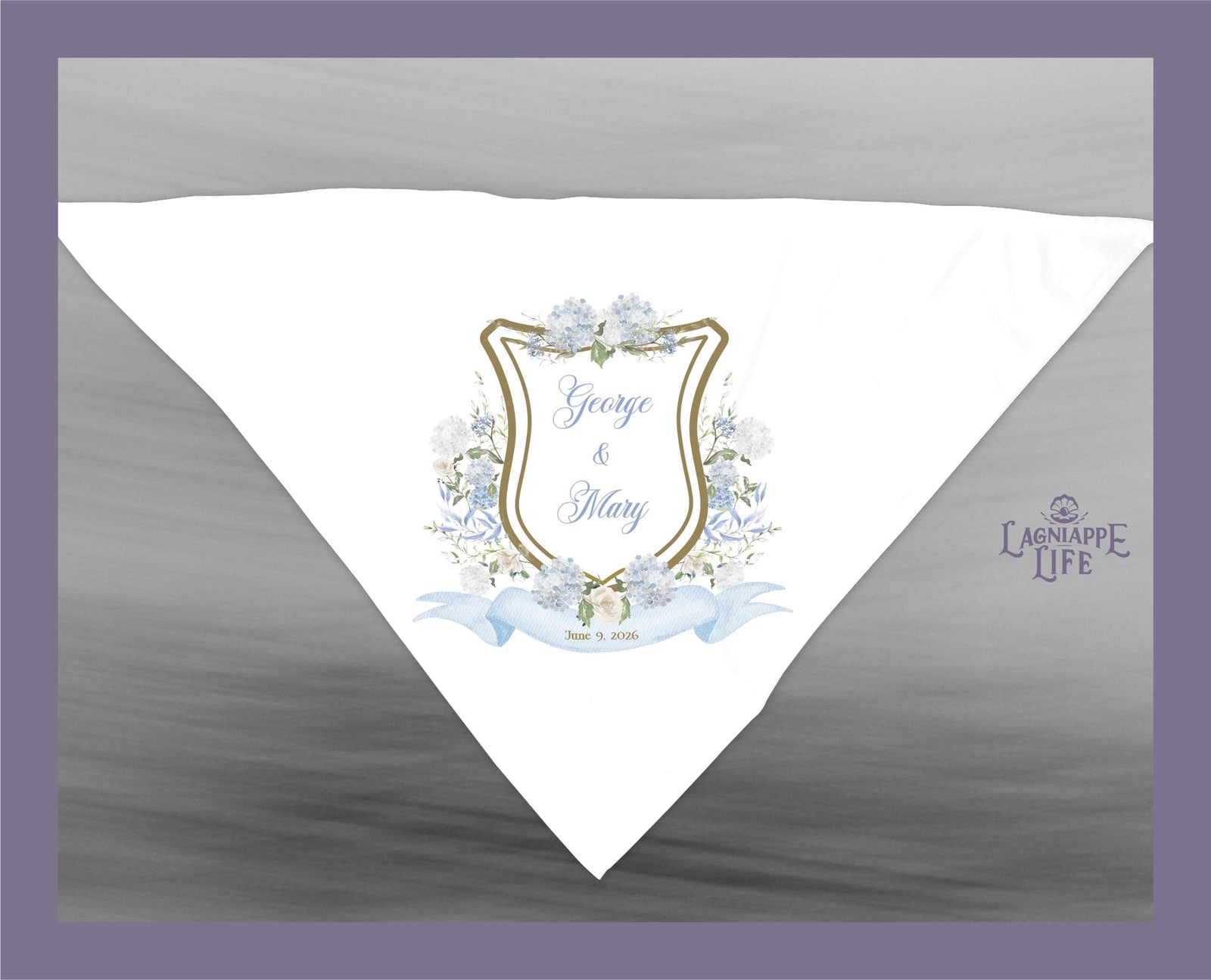 May include: A white wedding favor with a blue and gold crest. The crest has a floral design and the text 'George & Mary' and 'June 18, 2023'. The favor has the text 'Lagniappe Life' in the bottom right corner.